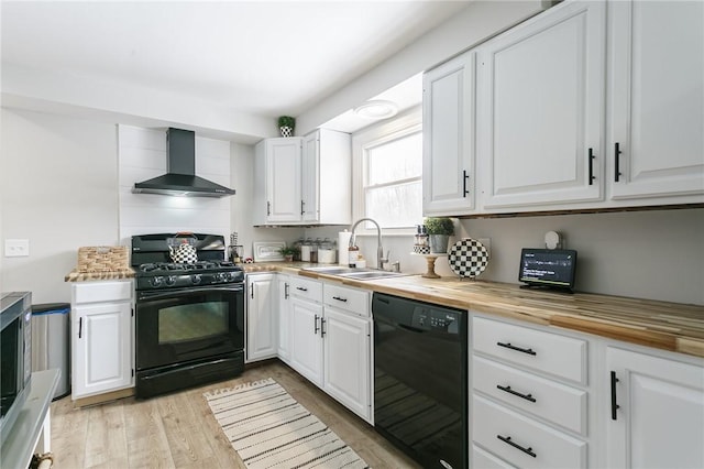 kitchen with a sink, black appliances, wood counters, and wall chimney exhaust hood