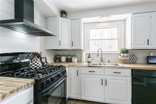 kitchen featuring white cabinets, a sink, wall chimney range hood, and black appliances