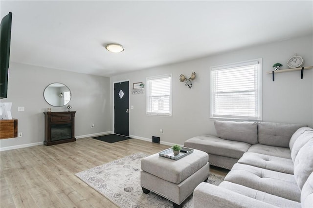 living area featuring light wood-style flooring and baseboards