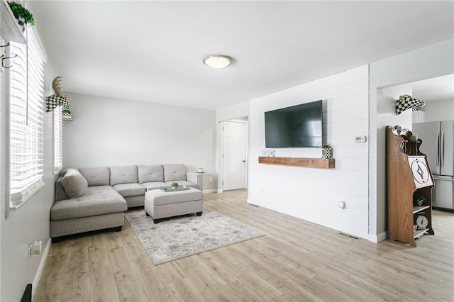 living room featuring visible vents, baseboards, and wood finished floors