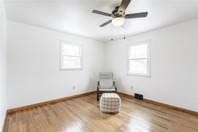 unfurnished room featuring light wood-type flooring, visible vents, ceiling fan, and baseboards