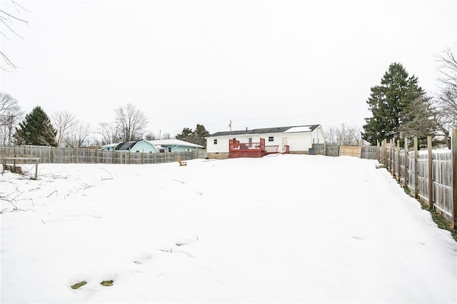 snowy yard featuring a fenced backyard