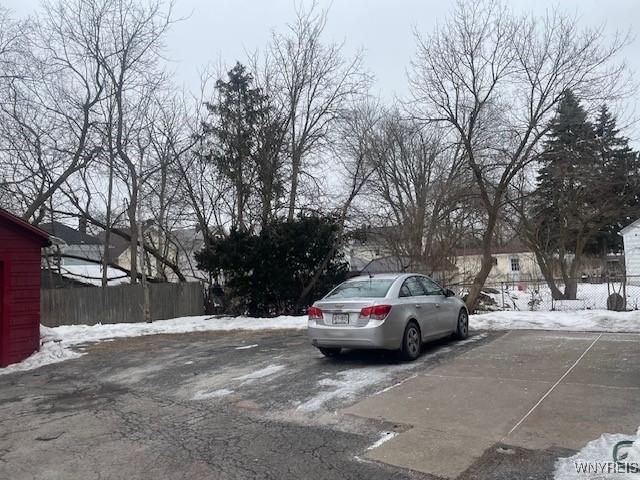 snow covered parking with fence