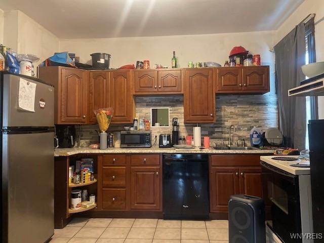 kitchen with stainless steel appliances, backsplash, a sink, and light countertops