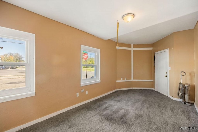 spare room featuring carpet flooring and baseboards