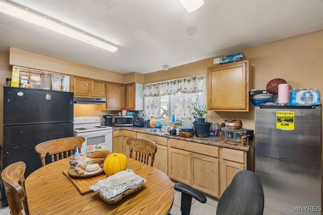 kitchen featuring appliances with stainless steel finishes, light countertops, a sink, and under cabinet range hood