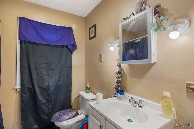 bathroom featuring a shower with curtain, vanity, and toilet