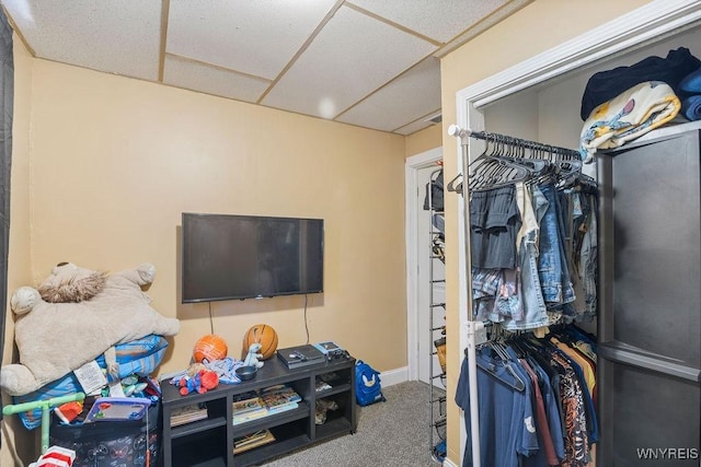 interior space with a paneled ceiling and baseboards