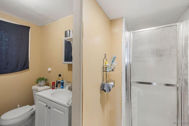 bathroom with a stall shower, vanity, and toilet