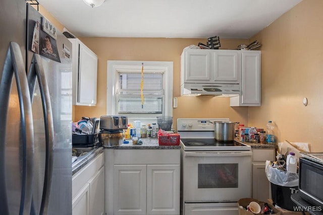 kitchen featuring black microwave, white cabinets, electric stove, freestanding refrigerator, and range hood