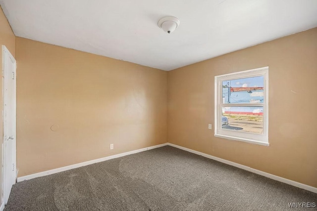 unfurnished room with carpet flooring and baseboards