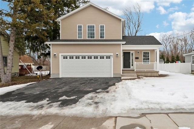 traditional-style house with a garage, covered porch, and driveway