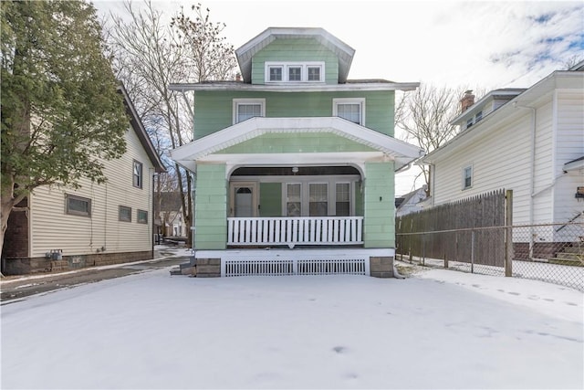 view of front facade featuring covered porch and fence