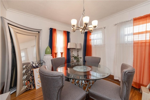 dining room featuring ornamental molding, a chandelier, and wood finished floors