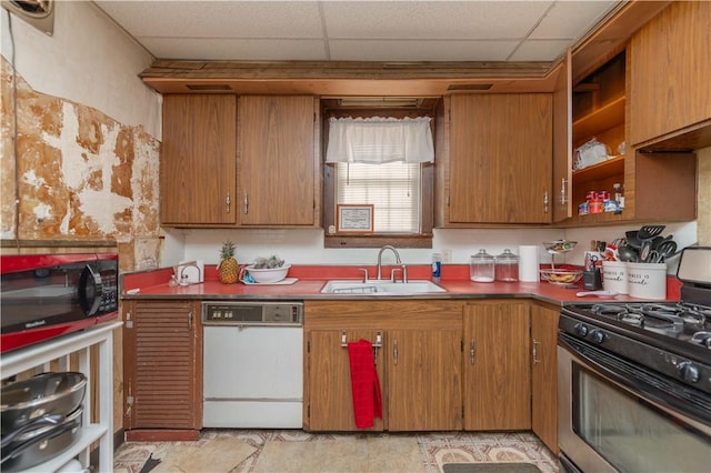 kitchen with a drop ceiling, dishwasher, a sink, and gas range