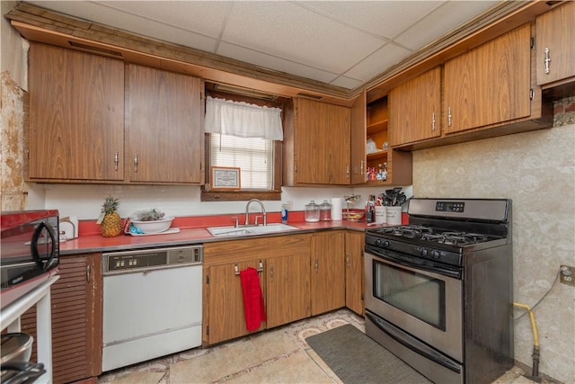 kitchen featuring dishwasher, a sink, stainless steel range with gas cooktop, and a paneled ceiling