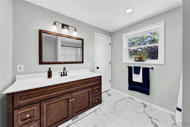 bathroom with marble finish floor, recessed lighting, vanity, and baseboards