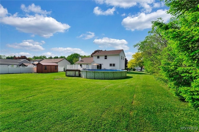 view of yard featuring a fenced in pool, an outdoor structure, a storage shed, and fence