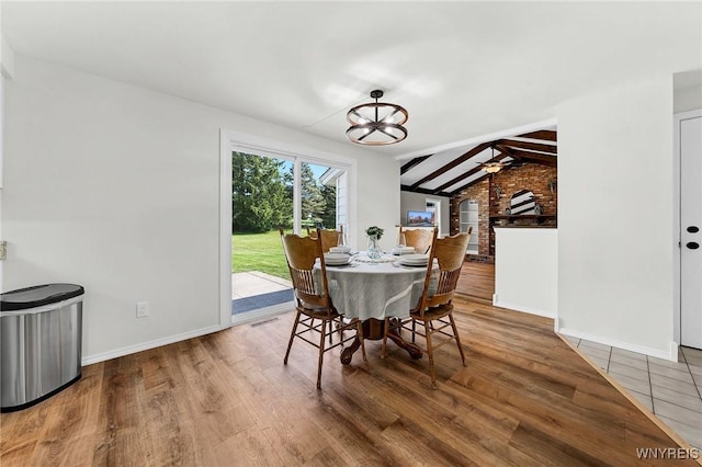 dining space with lofted ceiling with beams, wood finished floors, visible vents, and baseboards