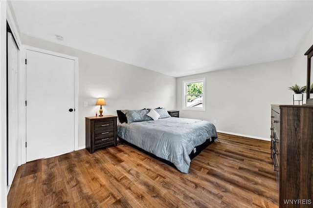 bedroom with dark wood-style flooring and baseboards