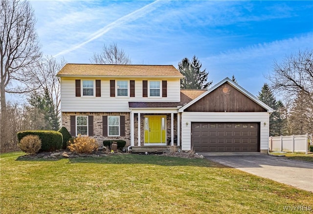 colonial home featuring driveway, a front yard, a garage, and fence