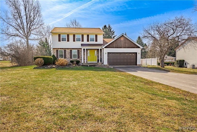 colonial house with a front yard, concrete driveway, a garage, and fence