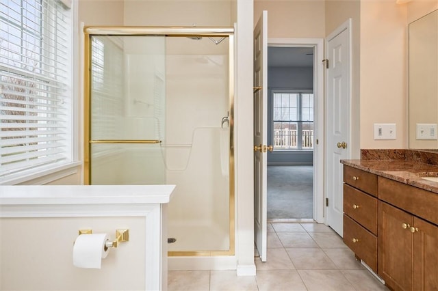 bathroom with a shower stall, tile patterned flooring, and vanity