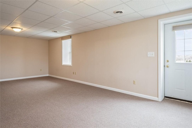 empty room with carpet floors, baseboards, visible vents, and a paneled ceiling