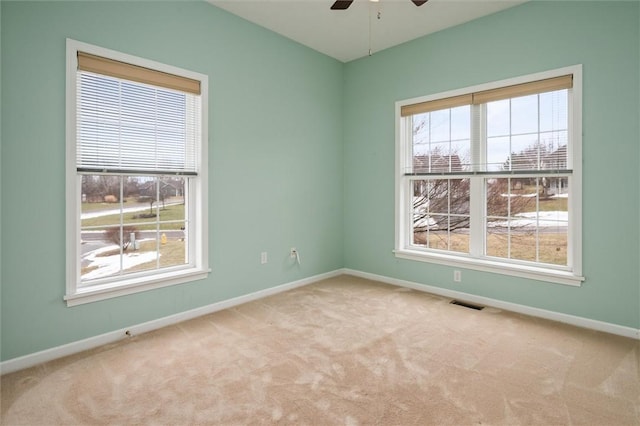 empty room featuring a healthy amount of sunlight, visible vents, and carpet flooring