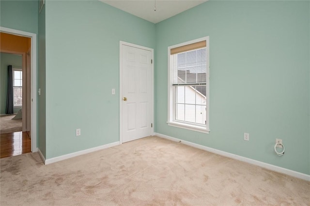 unfurnished bedroom featuring carpet, multiple windows, and baseboards