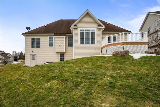 rear view of house with a deck and a lawn