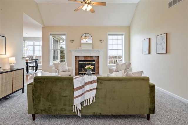 carpeted living room with plenty of natural light, a fireplace, visible vents, and vaulted ceiling