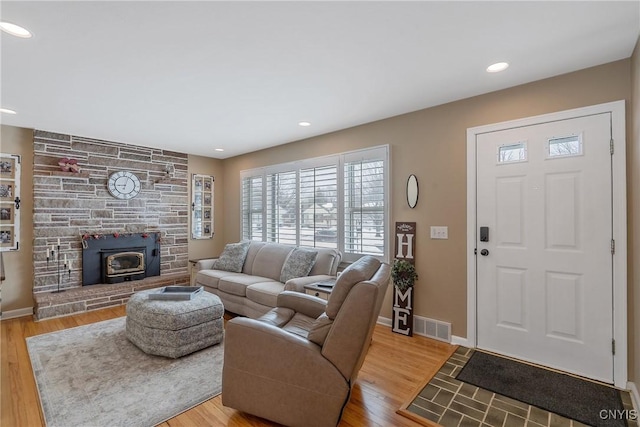 living area with light wood-type flooring, baseboards, and visible vents