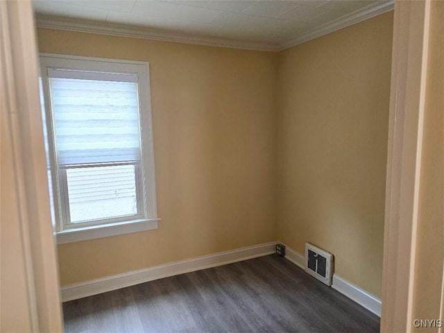 unfurnished room with crown molding, dark wood-type flooring, visible vents, and baseboards