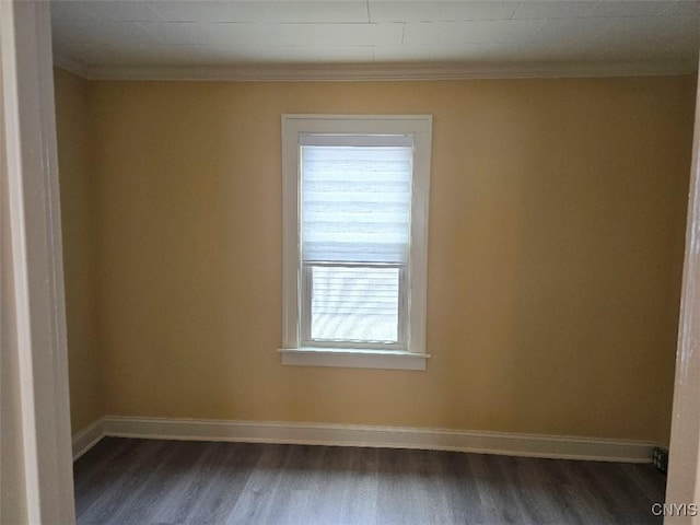 spare room with baseboards, dark wood-style flooring, and ornamental molding