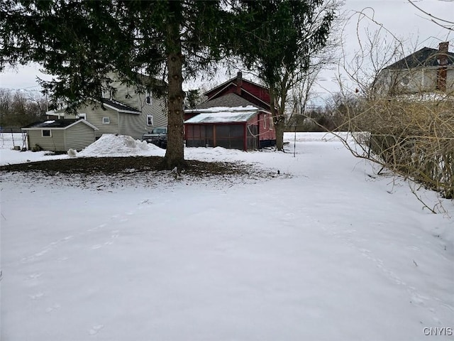 yard layered in snow with an outdoor structure