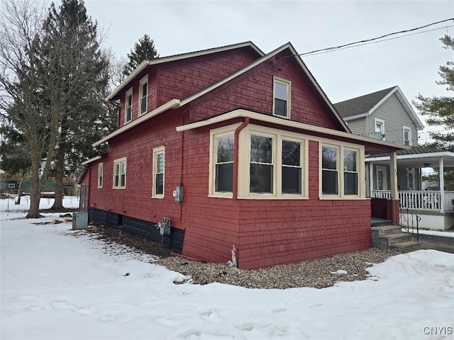 snow covered property featuring covered porch