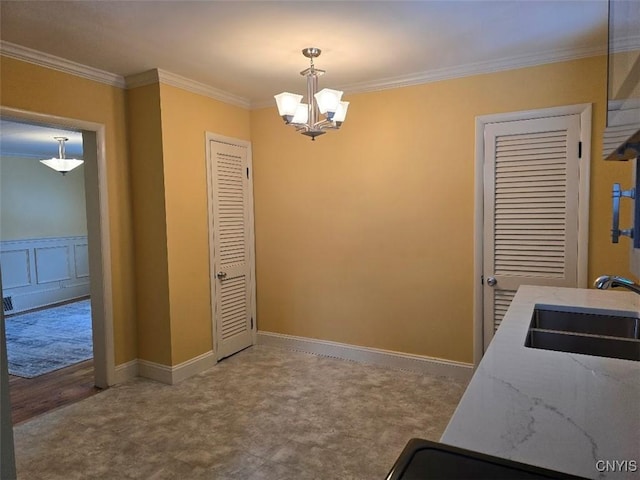 kitchen featuring crown molding, a sink, light stone countertops, decorative light fixtures, and an inviting chandelier