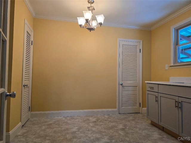 unfurnished dining area featuring an inviting chandelier, baseboards, and crown molding