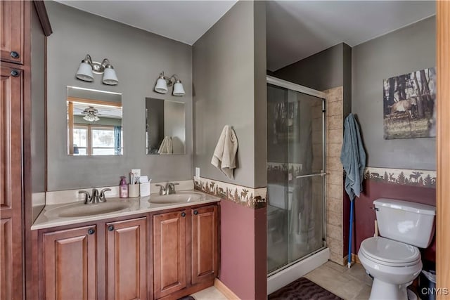 full bath with double vanity, a sink, toilet, and a shower stall