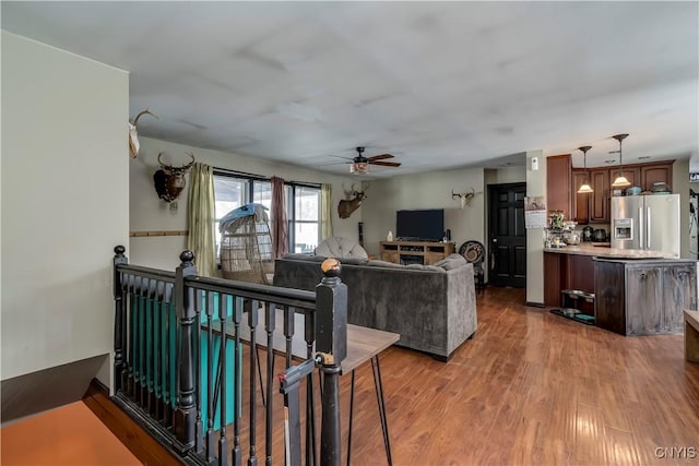 living area with wood finished floors and a ceiling fan