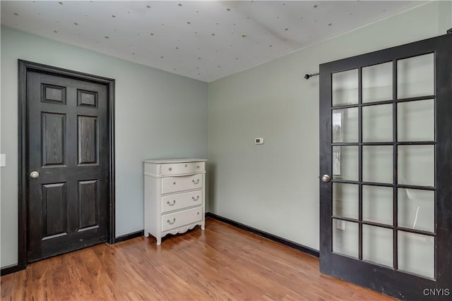 interior space with baseboards and wood finished floors