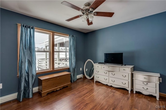 interior space with a baseboard heating unit, baseboards, and wood finished floors