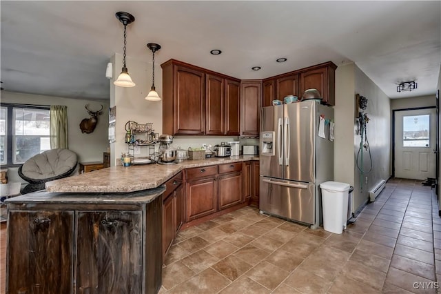 kitchen featuring stainless steel fridge, a baseboard radiator, open floor plan, a peninsula, and pendant lighting