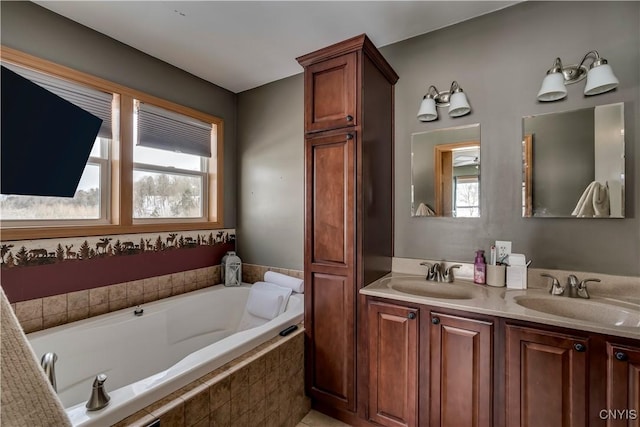 bathroom featuring a garden tub, a sink, and a healthy amount of sunlight