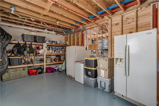 unfinished basement with white fridge with ice dispenser and freestanding refrigerator