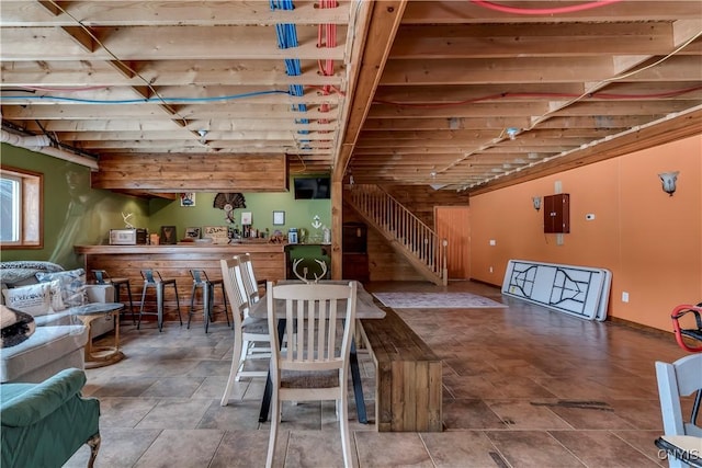 dining area featuring electric panel and stairs