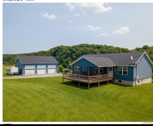 back of property with a garage, a yard, and an outdoor structure