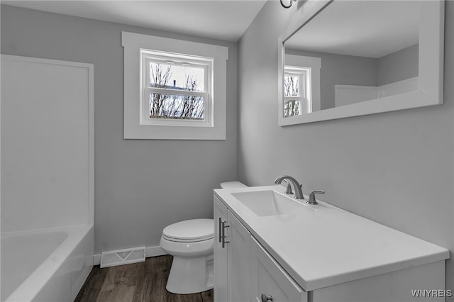 full bathroom featuring toilet, wood finished floors, vanity, visible vents, and baseboards