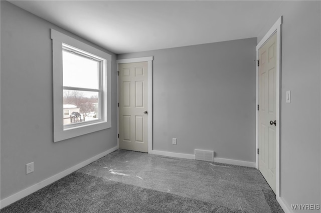 carpeted empty room with visible vents and baseboards